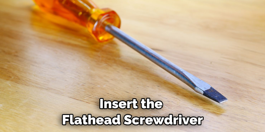 Insert the Flathead Screwdriver