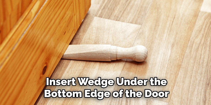 Insert Wedge Under the
Bottom Edge of the Door