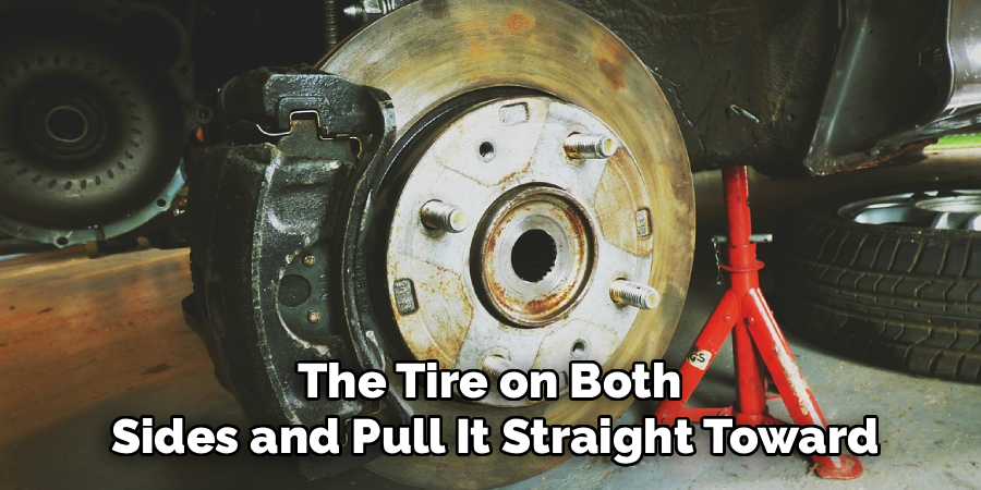 The Tire on Both 
Sides and Pull It Straight Toward